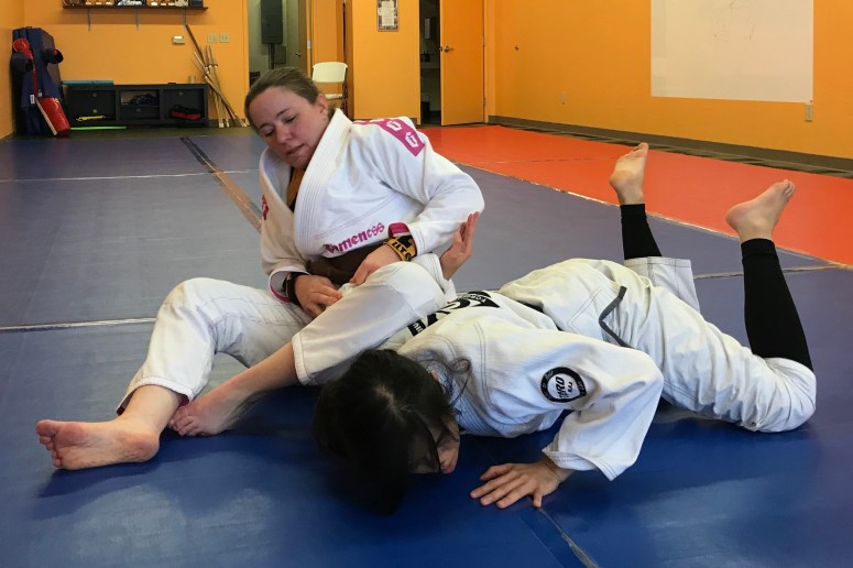 Jen flattens Liz preparing to finish the shoulder lock